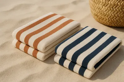 Serviettes de plage rayées pliées sur le sable